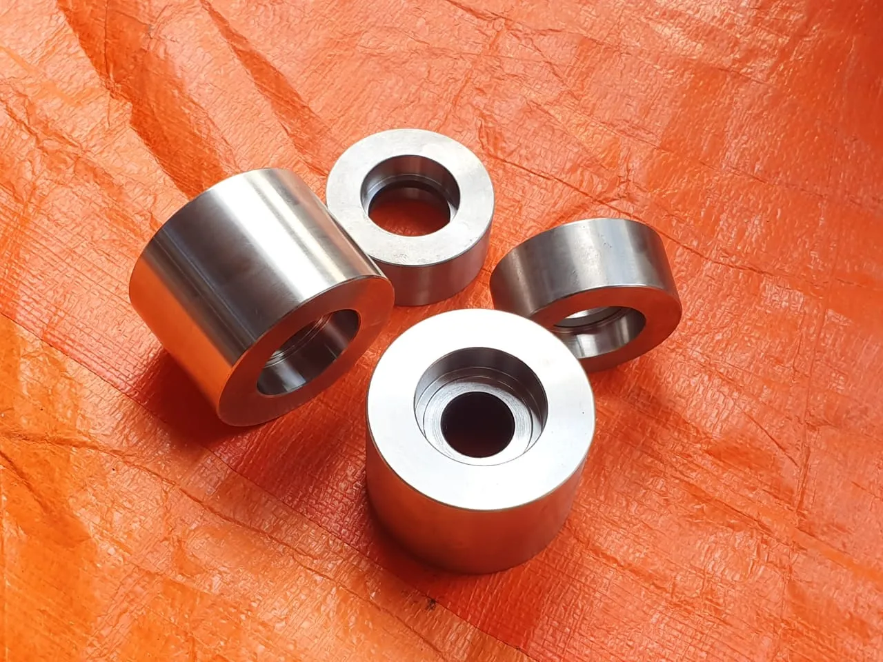 Turned guide rolls and bushings laid out before assembly
